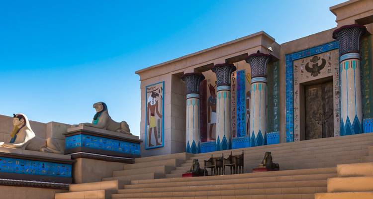 Kleurrijke replica van een oude Egyptische tempelfaçade bij een filmstudio met een heldere blauwe lucht boven je hoofd.