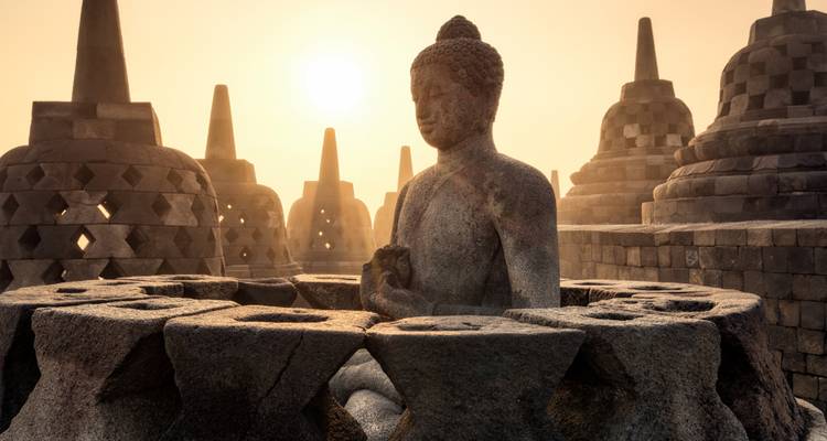 Ancient Buddhist temple during sunset with intricate stone carvings.