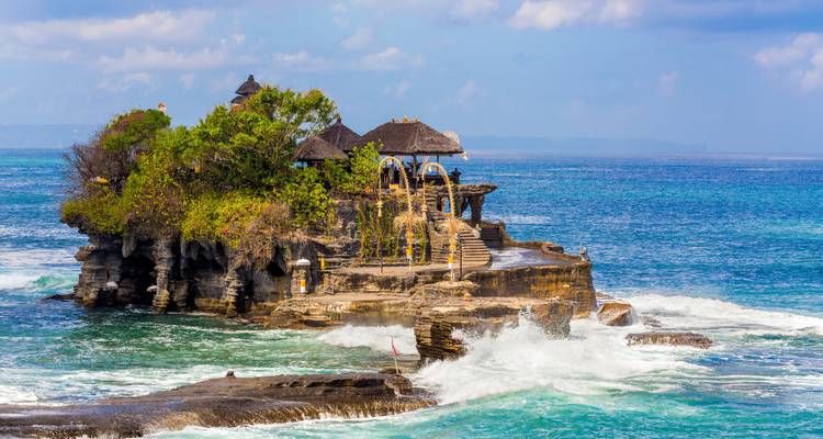 Temple on a rocky island surrounded by ocean waves.