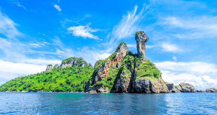 Île calcaire proéminente s'élevant d'une mer bleue.