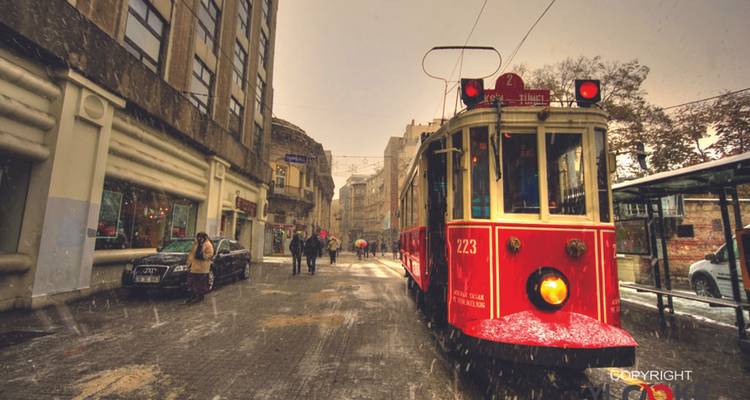 A tram in a rainy street in Istanbul with a visible watermark.