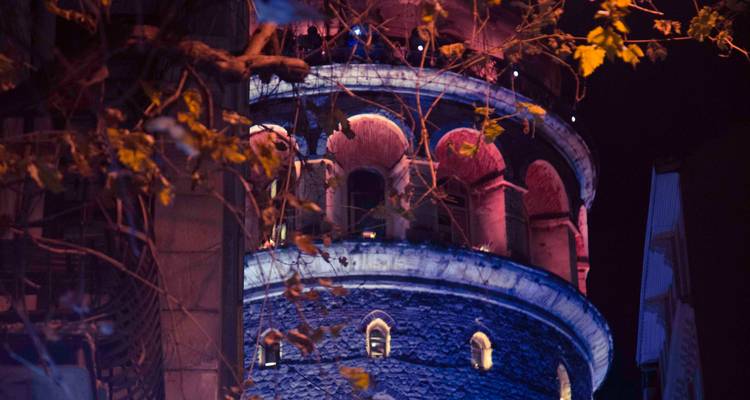 Galata Tower illuminated at night.