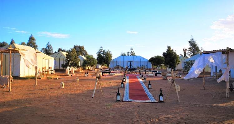 Een tentenkampeerterrein met een aangelegd pad en zitgelegenheid.