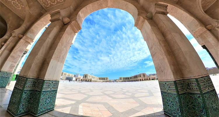 Binnenplaats met gewelfde zuilen en ingewikkelde mozaïeken.