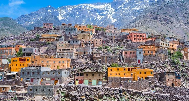 Colorful hillside village with mountains.