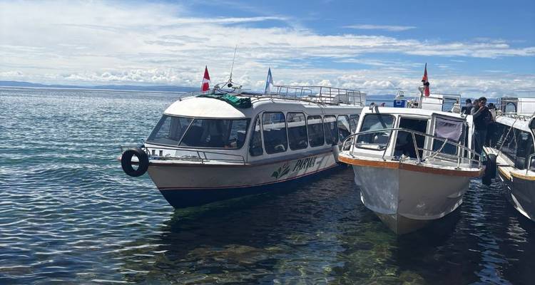 Des bateaux amarrés sur un lac avec des personnes à bord.