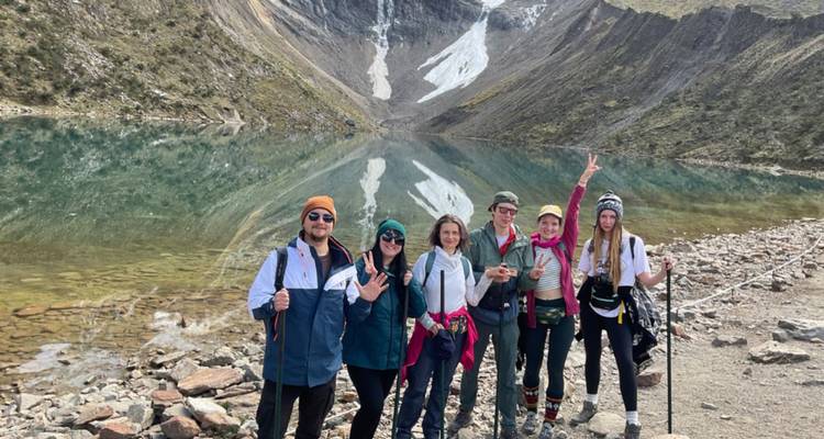 Groupe posant près d'un lac de montagne limpide.