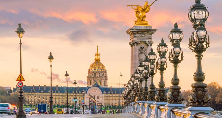 Brücke Alexandre III und die Kuppel von Les Invalides während eines romantischen Sonnenuntergangs.