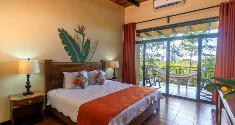 Une chambre élégante avec un lit confortable et une vue sur un paysage tropical luxuriant.