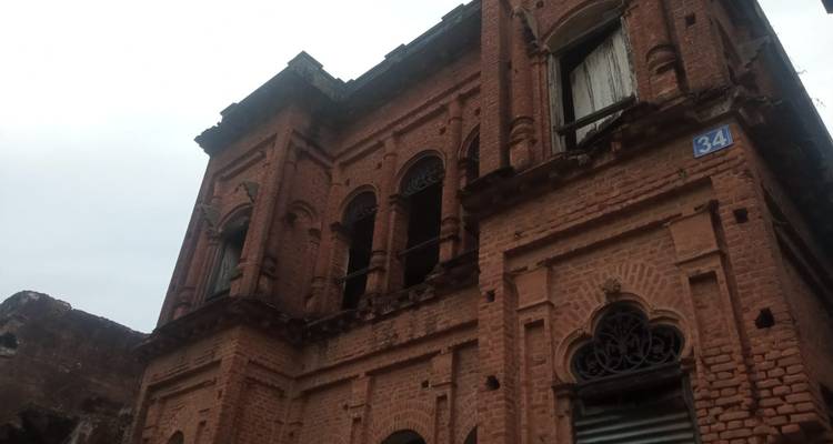 Edificio viejo de ladrillo con ventanas abiertas.