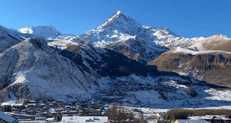 Montagne enneigée avec un village au pied.