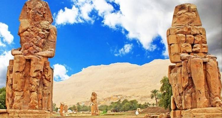 Kolossalstatuen von Memnon mit Bergen im Hintergrund.