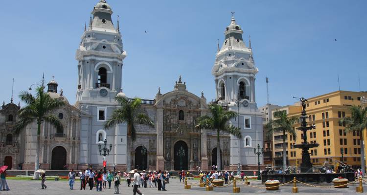 The Colonial architecture of the Cathedral of Lima with people walking in front.