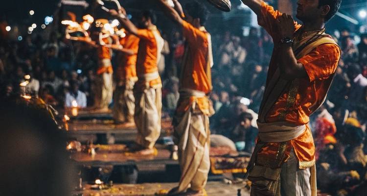 Meerdere mensen die deelnemen aan een traditionele Aarti-ceremonie 's nachts.