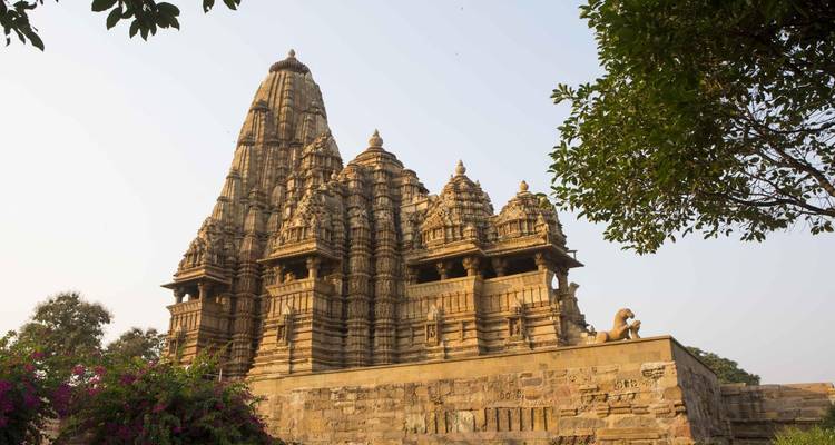 Historischer Tempel mit kunstvollen Schnitzereien vor klarem Himmel.