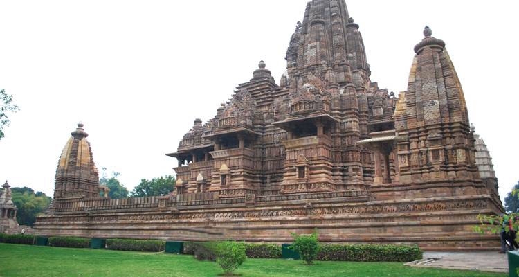 Detailansicht eines historischen Tempels mit blumiger Umgebung.