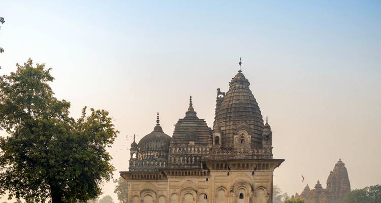 Tempel mit verzierten Kuppeln, umgeben von Nebel.