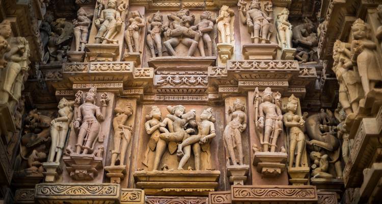 Kunstvolle Steinschnitzereien, die antike Szenen auf einer Tempelwand darstellen.