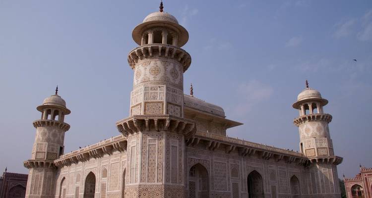 Weißes Marmormausoleum mit kunstvollen Verzierungen und vier Minaretten.
