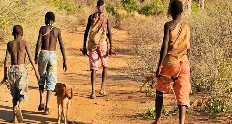 Menschen, die auf einem Feldweg mit einer Ziege gehen.