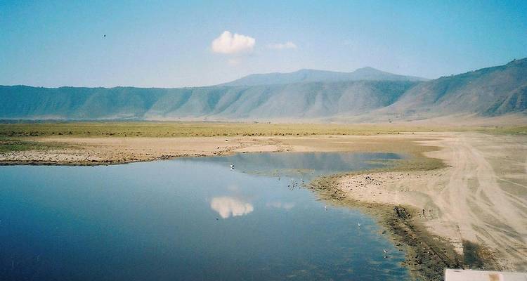 Eine ruhige Landschaft mit einem kleinen See und fernen Bergen.