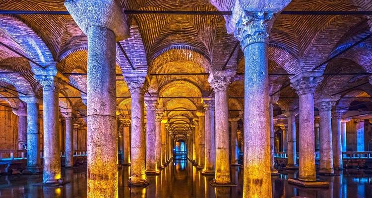 Underground ancient cistern with columns and colorful lighting.