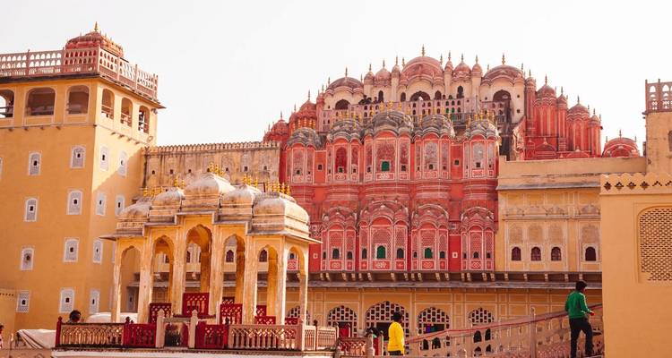 Frontansicht des Hawa Mahal in Jaipur mit Menschen drumherum.