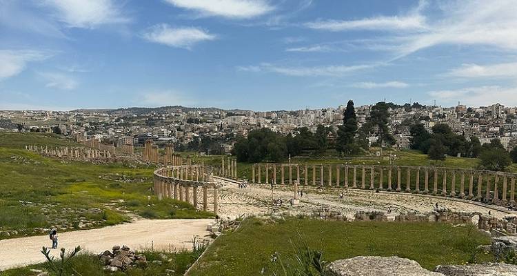 Ruins and columns set against a backdrop of a cityscape.