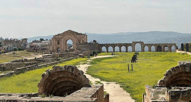 Expansive view of ancient ruins with greenery in foreground.