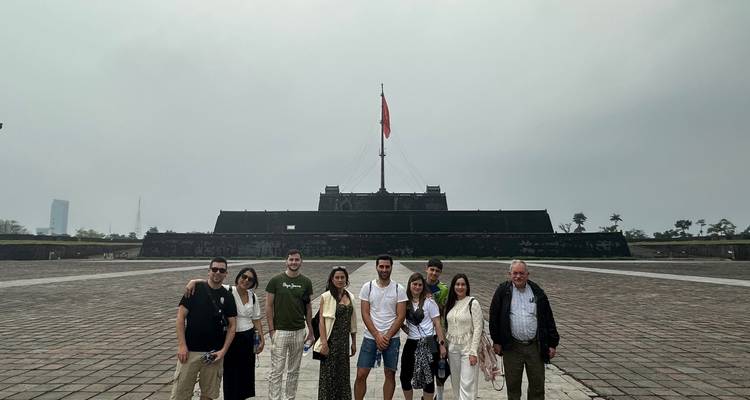 Groupe de touristes debout devant un monument de drapeau de grande taille.
