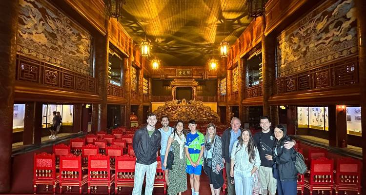 Groupe de touristes dans un grand hall avec des sièges rouges.