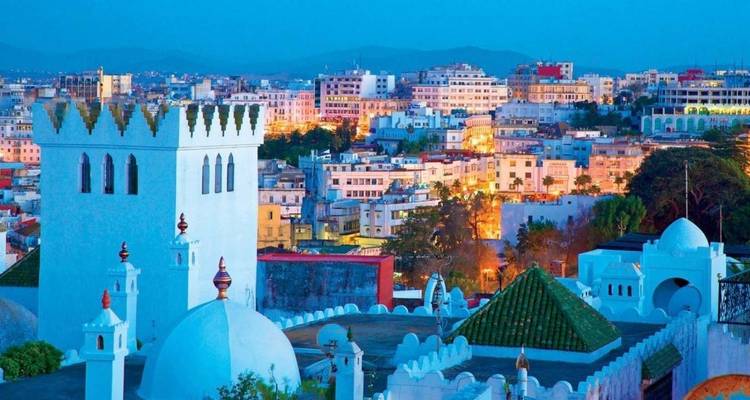 Cityscape at twilight with lit buildings.