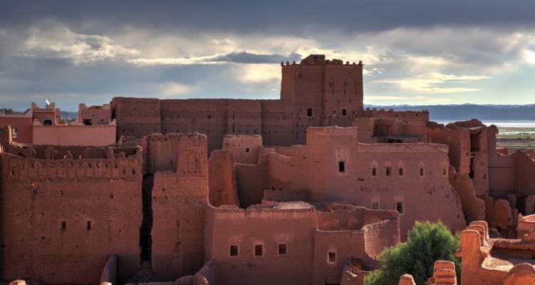 Ancient adobe buildings under a clouded sky.