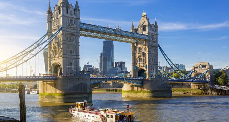 Sonniger Blick auf die Tower Bridge mit einem Boot, das in London darunter hindurchfährt.