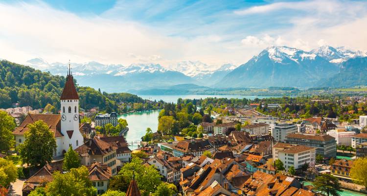 Panoramic view of a town by a lake with mountains in the distance.