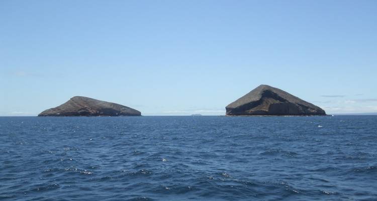 Deux îles avec des pics volcaniques vues à travers l'océan par une journée ensoleillée.