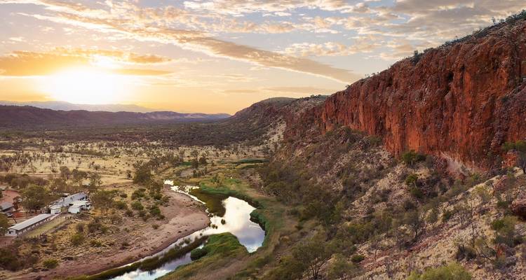 Lever de soleil sur un vaste paysage avec une rivière serpentant à travers la vallée.