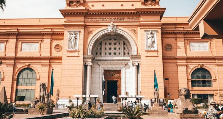 Frontansicht eines großen historischen Gebäudes mit Menschen, die ein- und ausgehen.