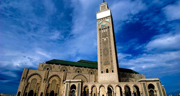 Hassan II-moskee in Casablanca met zijn torenhoge minaret tegen een blauwe hemel.
