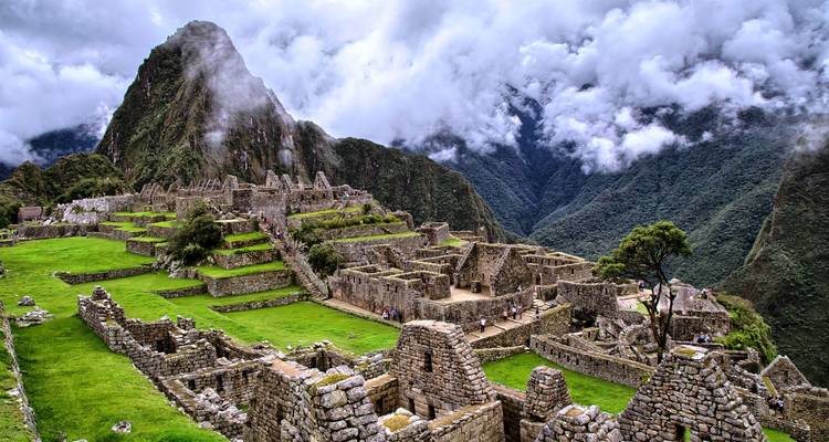 Panoramisch uitzicht op Machu Picchu omringd door bergen en wolken.