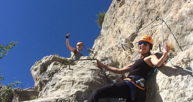 Zwei Kletterer, die mit Sicherheitsausrüstung eine Felswand erklimmen.