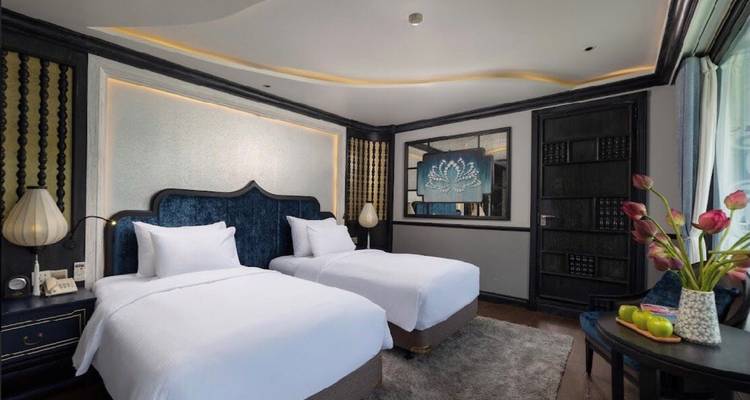 Hotelkamer met twee eenpersoonsbedden en elegante meubels.