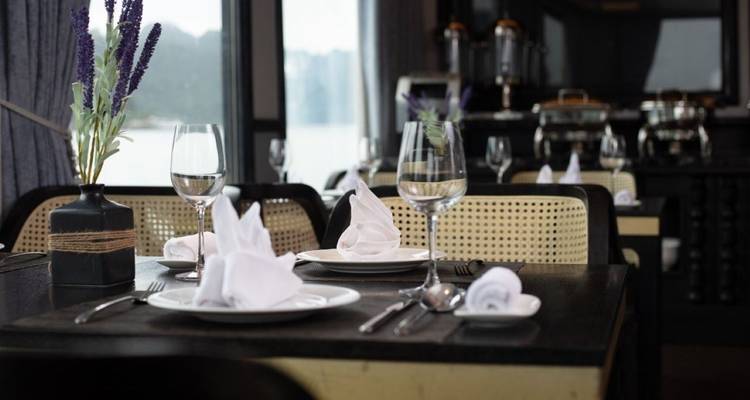 Tafelschikking met wijnglazen en uitzicht op het water.