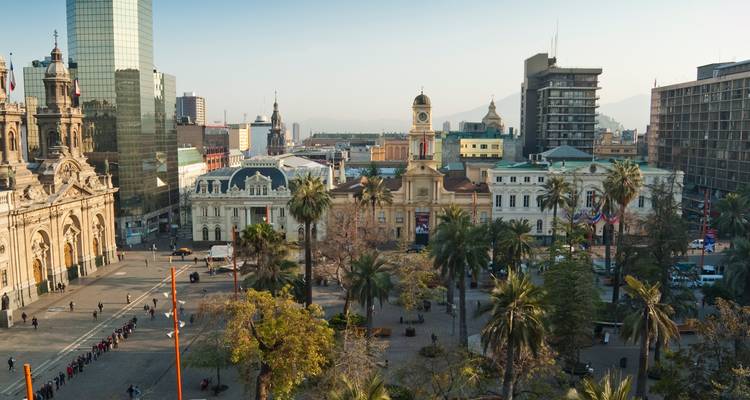An aerial view of Santiago’s historic Plaza de Armas surrounded by colonial and modern buildings.