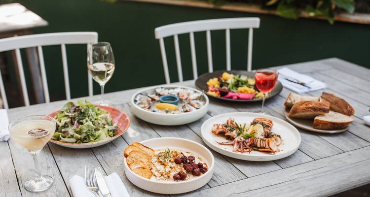 Gemengde zeevruchten en salades op een tafel met drankjes.