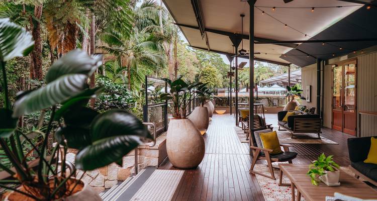 Buitenlounge met zitplaatsen en planten met uitzicht op een schilderachtig landschap.