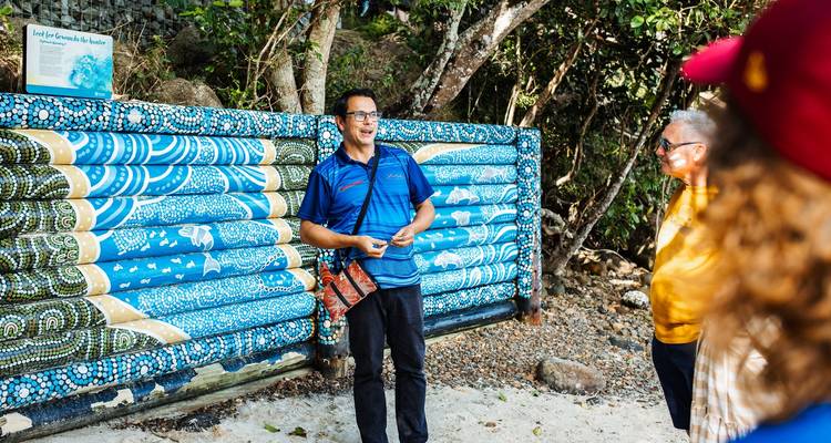 Grupo escuchando a un guía con detalles decorativos en la pared.