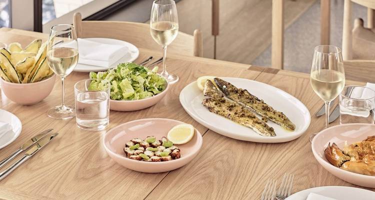 Eettafel met verschillende gerechten en wijnglazen.