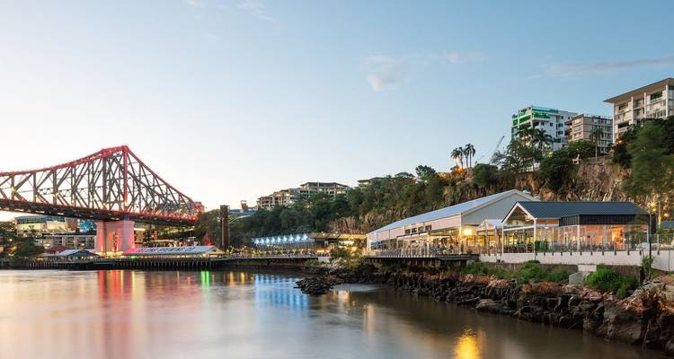 Rivieroeverzicht met een brug en gebouwen.