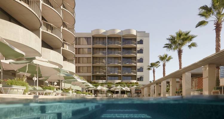 Buitenkant van een hotel met een zwembad.